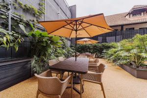 ein Tisch und Stühle mit einem Sonnenschirm auf einer Terrasse in der Unterkunft Morse Residencial Flipchave MOR000 in Joinville