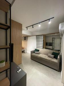 a living room with a couch and a kitchen at Morse Residencial Flipchave MOR000 in Joinville