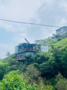 ein Haus am Hang eines Hügels in der Unterkunft River Side Gorilla Resort Mussoorie in Masuri