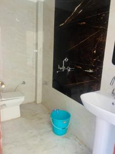 ein Badezimmer mit einem Waschbecken und einem blauen Eimer in der Unterkunft River Side Gorilla Resort Mussoorie in Masuri