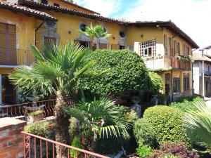 a house with palm trees in front of it at Garden Apartment in Lesa