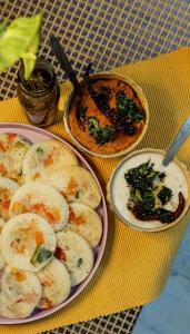 a table with two plates of food on a table at Ostel In in Puducherry