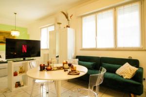 a living room with a green couch and a table at Casa Violante in Ancona