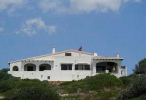 een wit huis bovenop een heuvel bij Binibeca Panorama incredibile in Sant Lluis