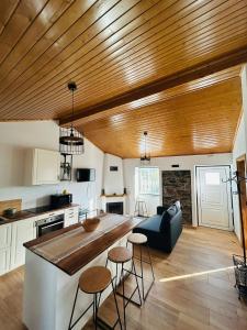 a kitchen with a wooden ceiling and a large kitchen island at Casinha da Relva 