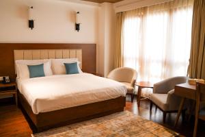 Un dormitorio con una cama, un escritorio y una silla. en The 33rd Executive Suites, en Thimphu