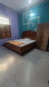 a bedroom with two beds and a blue wall at Nangli Homestay in Meerut +4 photos