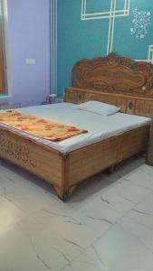 a large wooden bed in a room with at Nangli Homestay in Meerut
