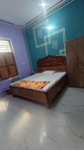 a bedroom with a bed and a blue wall at Nangli Homestay in Meerut +2 photos