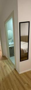 a mirror in a room with a bed and a desk at Vibe Comfort Tirana in Tirana