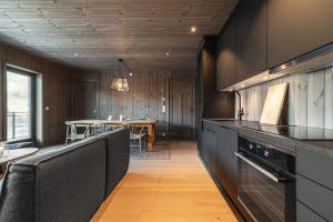 een keuken met zwarte kasten en een tafel op de achtergrond bij Fjellnest Hemsedal in Hemsedal