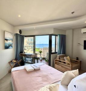 Un dormitorio con una cama grande y vista al mar. en TDJ Japandi Studio in Tambuli Seaside Living Fully Equipped, en Maribago