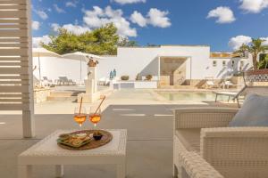 a table with a plate of food and two glasses of wine at I Mirti - Home Holiday in Marina di Mancaversa