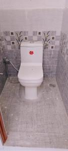 a bathroom with a white toilet in a room at Nangli Homestay in Meerut