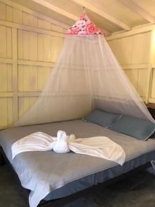 a bed with a net on top of it at Baan Suan Coconut Ko Yao Noi in Ko Yao Noi