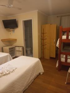 een kamer met twee bedden en een tv aan de muur bij Pousada Eco Da Montanha in Passa Quatro