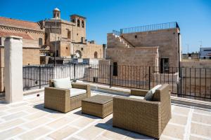 a patio with two couches and chairs on a roof at Le Casine di Maruggio Albergo Diffuso in Maruggio