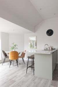 een keuken en eetkamer met een tafel en stoelen bij Luxury Fully Equipped Kitchen Ormeau Park in Belfast