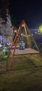 a person sitting on a swing seat in a park at Green River Camp in Rishīkesh