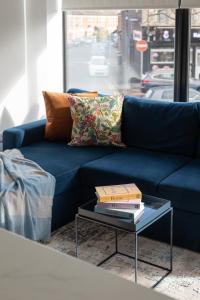 een blauwe bank met twee boeken op een salontafel bij Luxury Fully Equipped Kitchen Ormeau Park in Belfast