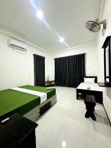 a room with two beds and a table in it at Flora Lake View Resort Wilpattu in Wilpattu