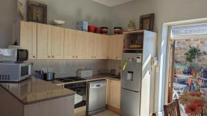 a kitchen with a refrigerator and a stove top oven at Dalebrook Sea-Facing Apartment in Kalk Bay in St James +7 photos