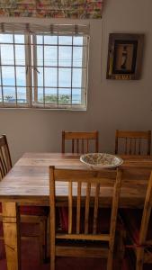 a dining room table with chairs and a plate on it at Dalebrook Sea-Facing Apartment in Kalk Bay in St James