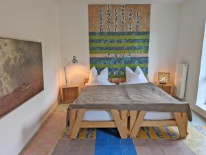 een slaapkamer met een tafel en een schilderij aan de muur bij Gästehaus Loreley - Alte Heerstrasse in Fellen