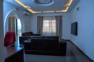 a living room with two couches and a tv at MICASO Guest House in Limbe