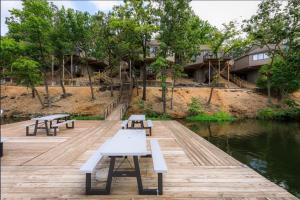 a group of benches sitting on a dock next to the water at Lakefront Home-3bd25badockgrillfirepitpool in Arrowhead Beach