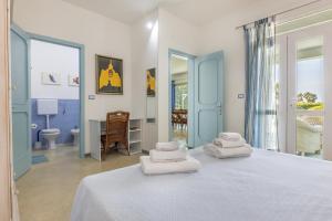 a bedroom with a bed with towels on it at I Mirti - Home Holiday in Marina di Mancaversa +87 photos