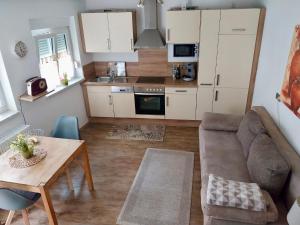 una sala de estar con un sofá y una mesa en Ferienwohnung Familie Westermann, en Kapellen-Drusweiler