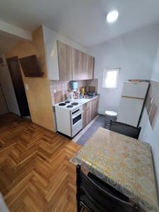 Una cocina con una mesa y un horno blanco. en Rooms3, en Beograd