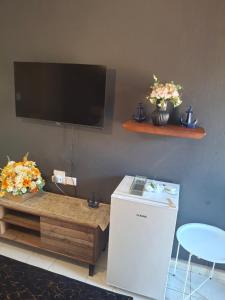a living room with a table and a tv and flowers at The Private Location in Thohoyandou