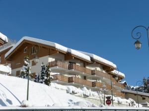 Un edificio cubierto de nieve con una farola. en 2 Pièces 4 Pers, Proximité commerces, Garage et Ascenseur - FR-1-304-12, en La Clusaz