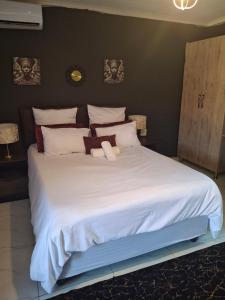a large bed with white sheets and pillows at The Private Location in Thohoyandou