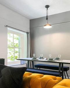 a living room with a table and a yellow couch at Pavilion Mews Luxury Apartment in Buxton