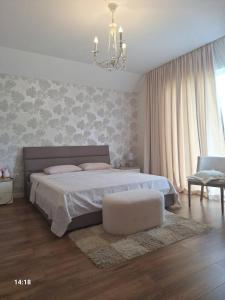 a bedroom with a bed and a chair and a chandelier at Tsitadel in Zugdidi