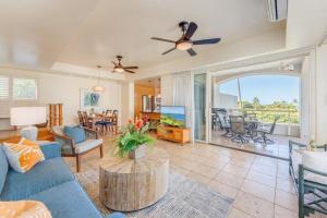a living room with a blue couch and a table at Palms at Wailea 2108 · PAW 2108 Remodeled Wailea Condo w AC Infi in Wailea