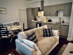 a living room with a couch and a kitchen at Clubhouse, North End, Bedale DL8 1AB in Bedale