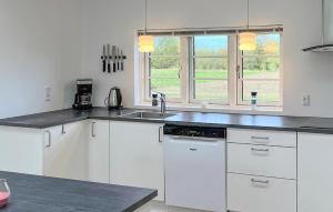 a kitchen with white cabinets and a sink at Stunning Home In Sydals With Sauna in Skovbyballe
