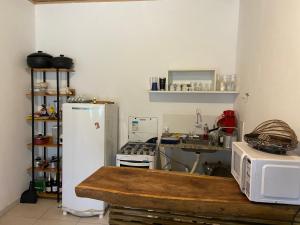 a kitchen with a refrigerator and a microwave at Apartamentos da Casa Azul in Trancoso
