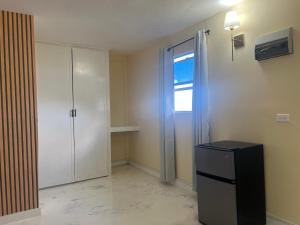 an empty room with a refrigerator and a window at Lovely 2 bedroom in the city in Saint Georgeʼs