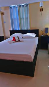 a bed with a black frame and white sheets and pillows at Lovely 2 bedroom in the city in Saint Georgeʼs