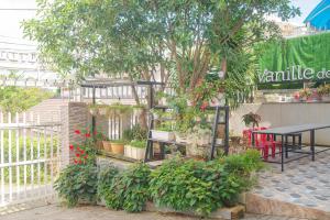 a garden with a table and a bunch of plants at Vanille De House in Xuan An
