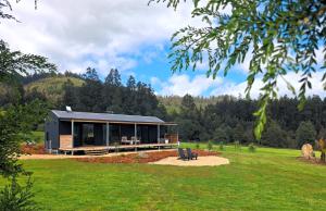 a house with a black roof in a field at Maydena Alpine Retreat in Maydena