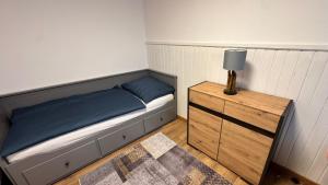 a small bedroom with a bed and a lamp on a dresser at Ferienwohnung Dörfl in Glödnitz, Carinthia in Glödnitz +6 photos