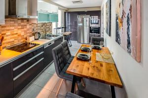 a kitchen with a wooden table and chairs at Sky-High 1BR 30 Floor Spa,Gym Cevahir Tower A in Skopje