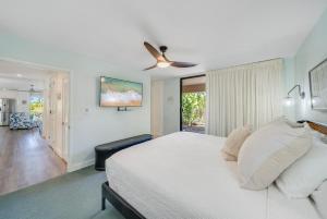 a bedroom with a white bed and a ceiling fan at Wailea Ekahi 21A · WEK 21A Remodeled Wailea Condo Pool AC Near B in Wailea +56 photos