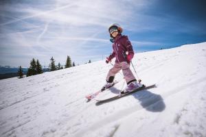 a young girl is skiing down a snow covered slope at GITE COSY "LE CLAIRBIER" AVEC CHEMINEE ET JACUZZI à St Laurent en Grandvaux in Saint-Laurent-en-Grandvaux
